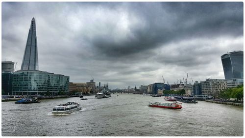 Boats in river with city in background