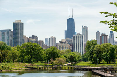 Trees and buildings in city against sky chicago skyline