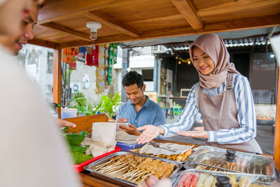 Portrait of young woman preparing food at restaurant