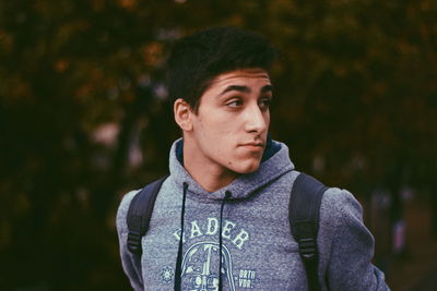 Portrait of young man looking away outdoors