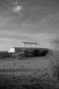 Barn on field against sky