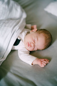 High angle view of baby sleeping on bed