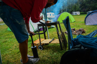 Man burning firewood at campsite