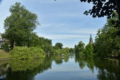 Scenic view of lake by trees against sky