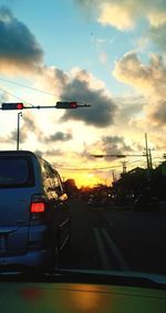 Cars on road against sky during sunset