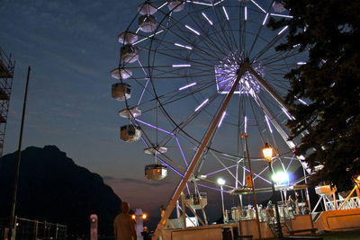 Low angle view of illuminated ferris wheel against sky at night