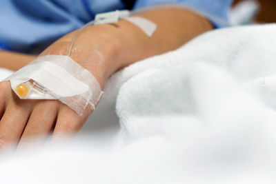 Close-up of woman hand with medical equipment on bed