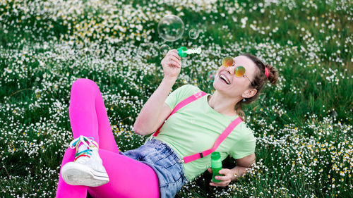 Woman wearing sunglasses sitting on plants