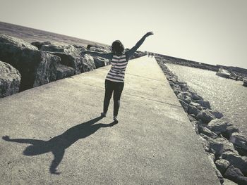 Full length of woman standing on footpath