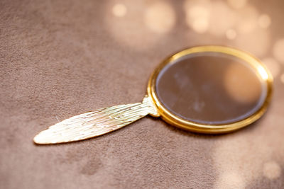 Close-up of hand mirror on table