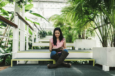 Beautiful agronomical engineer taking notes in the greenhouse