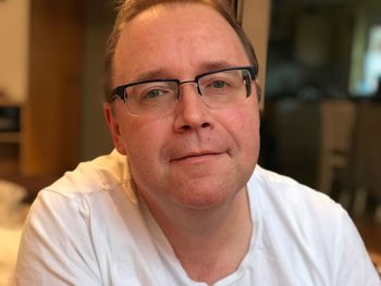 Portrait of man wearing eyeglasses at home