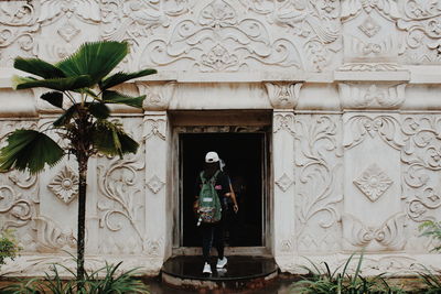 Statue of woman standing in front of built structure