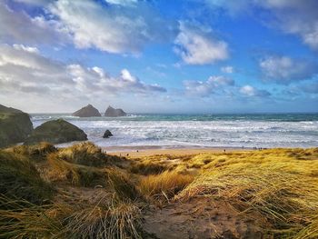 Scenic view of beach against cloudy sky