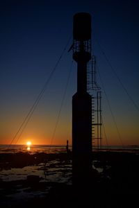 Silhouette of communications tower at sunset