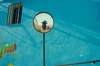 Reflection of man seen in mirror against wall