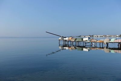 Crane by sea against clear sky