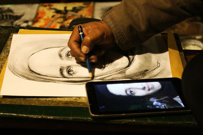 Midsection of man using mobile phone on table