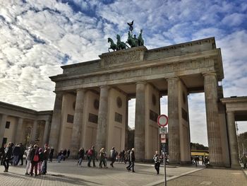 People at brandenburg gate against sky during sunny day
