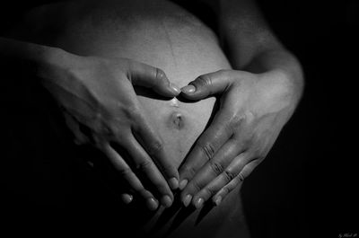 Close-up of couple hands against black background