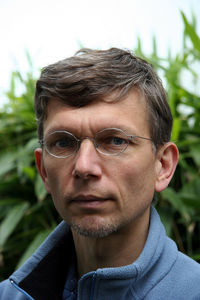 Portrait of mature man wearing eyeglasses against plants