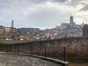 View of buildings in city against cloudy sky