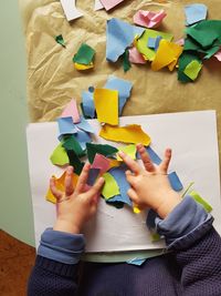 High angle view of child hand holding paper