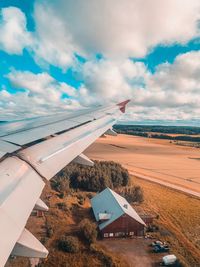 Airplane flying over landscape against sky