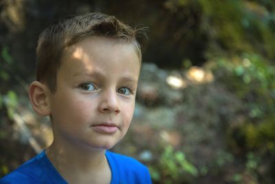Close-up portrait of cute boy in forest