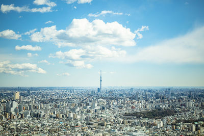 Aerial view of city against cloudy sky