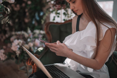 Midsection of woman using mobile phone outdoors