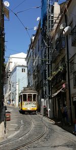 Cars on street in city against sky