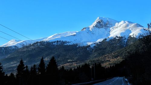 Scenic view of snowcapped mountains against blue sky