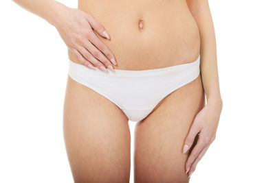 Midsection of woman standing against white background