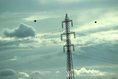 Low angle view of electricity pylon against sky