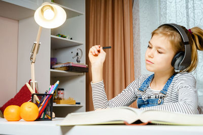 Girl sitting on table at home