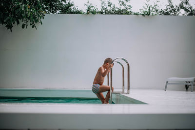 Full length of shirtless man in swimming pool