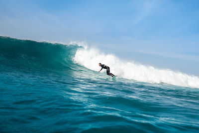 Man surfing in sea against sky