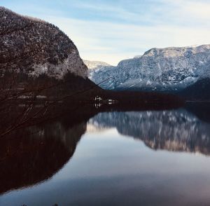 Scenic view of lake by mountains against sky