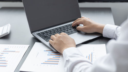 Low section of man using laptop on table