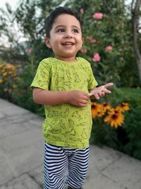 Smiling boy standing on footpath at park
