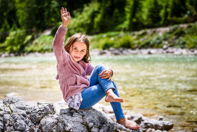 Full length of girl sitting on rock