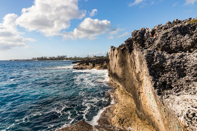 Rock formation on beach against sky