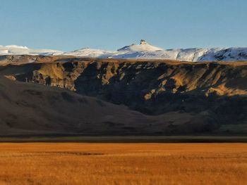 Scenic view of field and mountains against clear sky