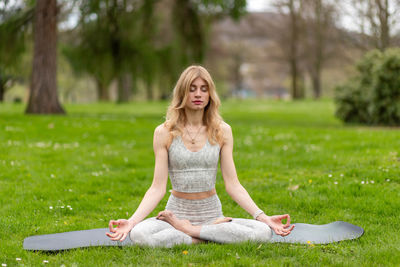 Portrait of young woman sitting on field