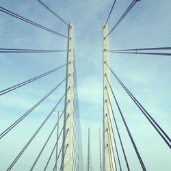 Low angle view of electricity pylon against blue sky