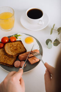 English breakfast with black coffee and orange juice, grilled sausage and whole wheat toast