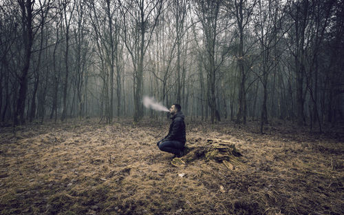 Man smoking in forest during winter