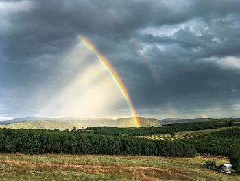 Scenic view of rainbow over landscape against sky