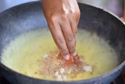 Cropped hand of man preparing food in bowl